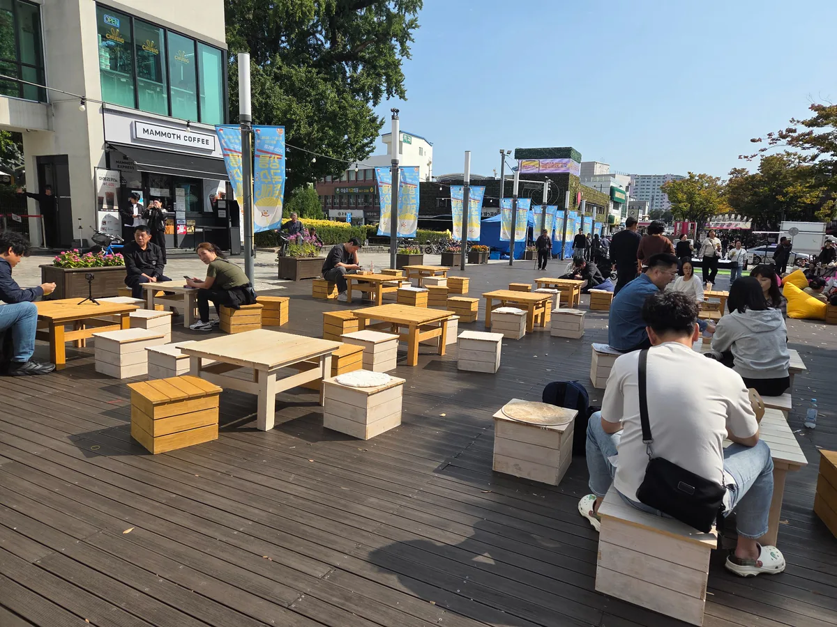 Outdoor dining tables near the festival performance area